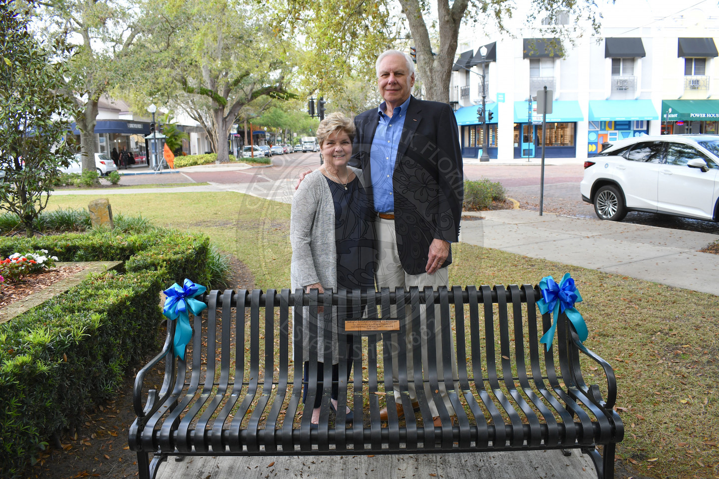 man and woman standing behind dedicated bench