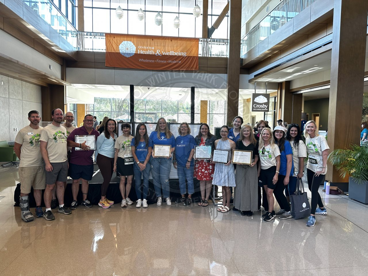 Group photo of all the green school grant recipients. The recipients are holding certificates of their award with staff their staff and city of winter park staff in the photo.