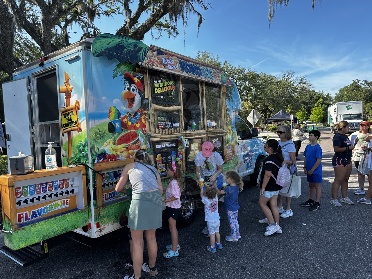 kids lined up with thier parents to get Kona Ice.