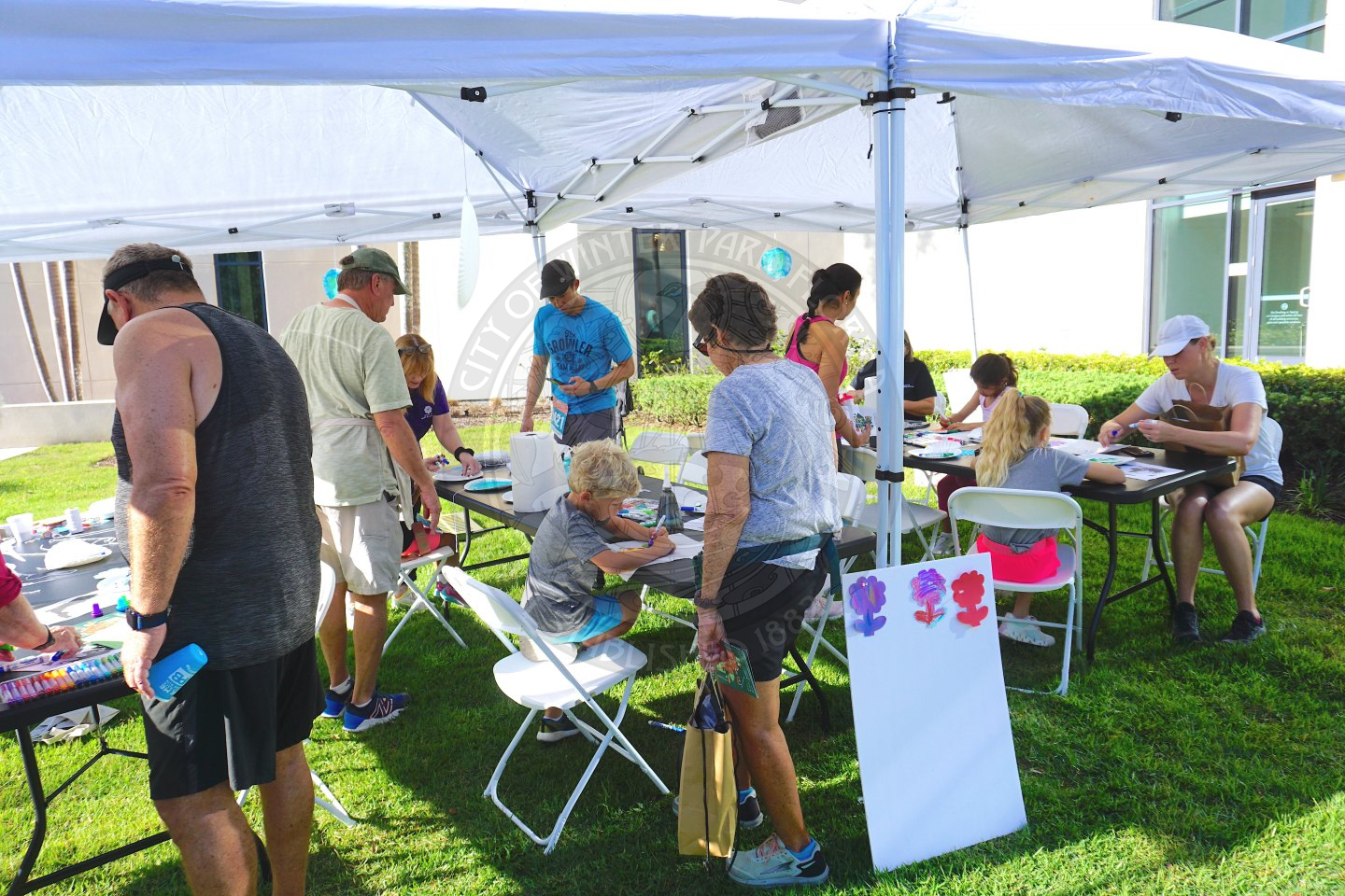 tables under a tent with kids and adults creating crafts