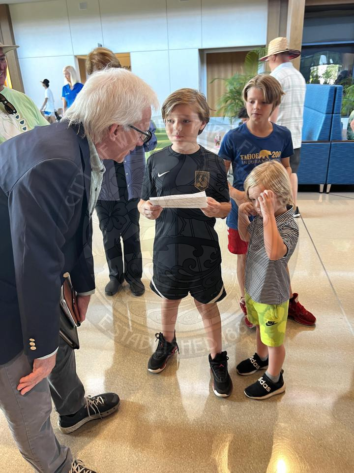 Mayor Anderson bending down talking to 2 boys