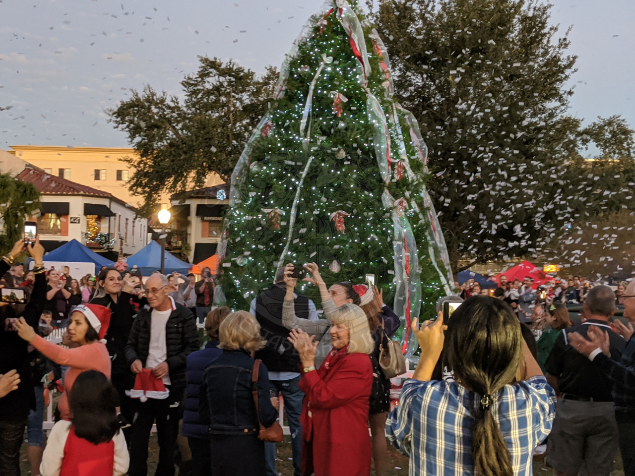 people standing under confetti during the holiday tree lighting