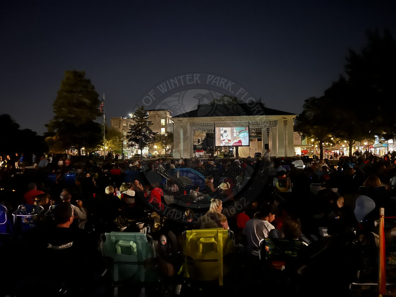 People sitting in front of the stage watching a christmas movie.