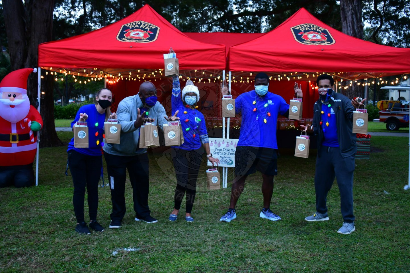three men and two women outside holding goodie bags