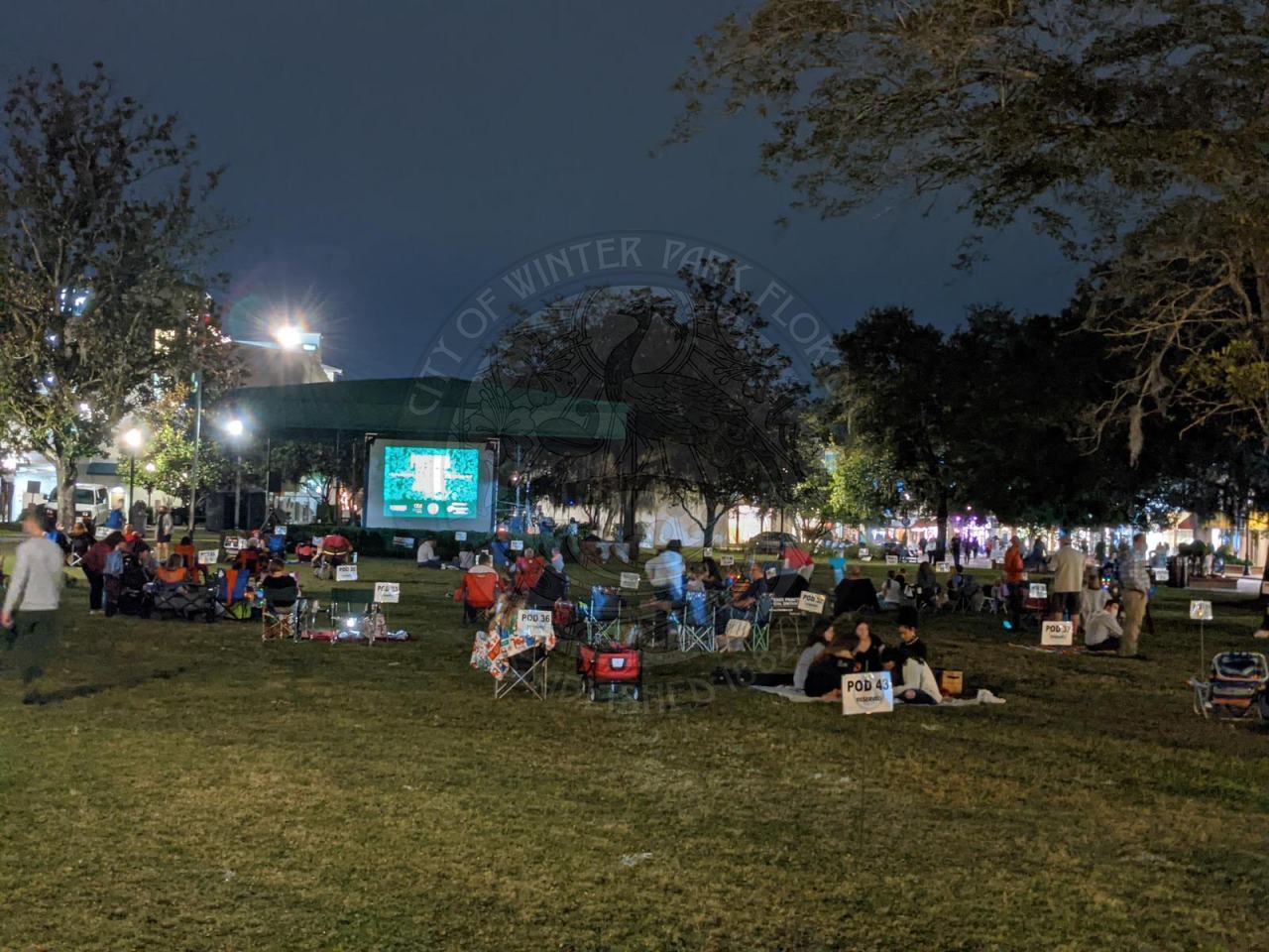 people sitting in movie pods in the park