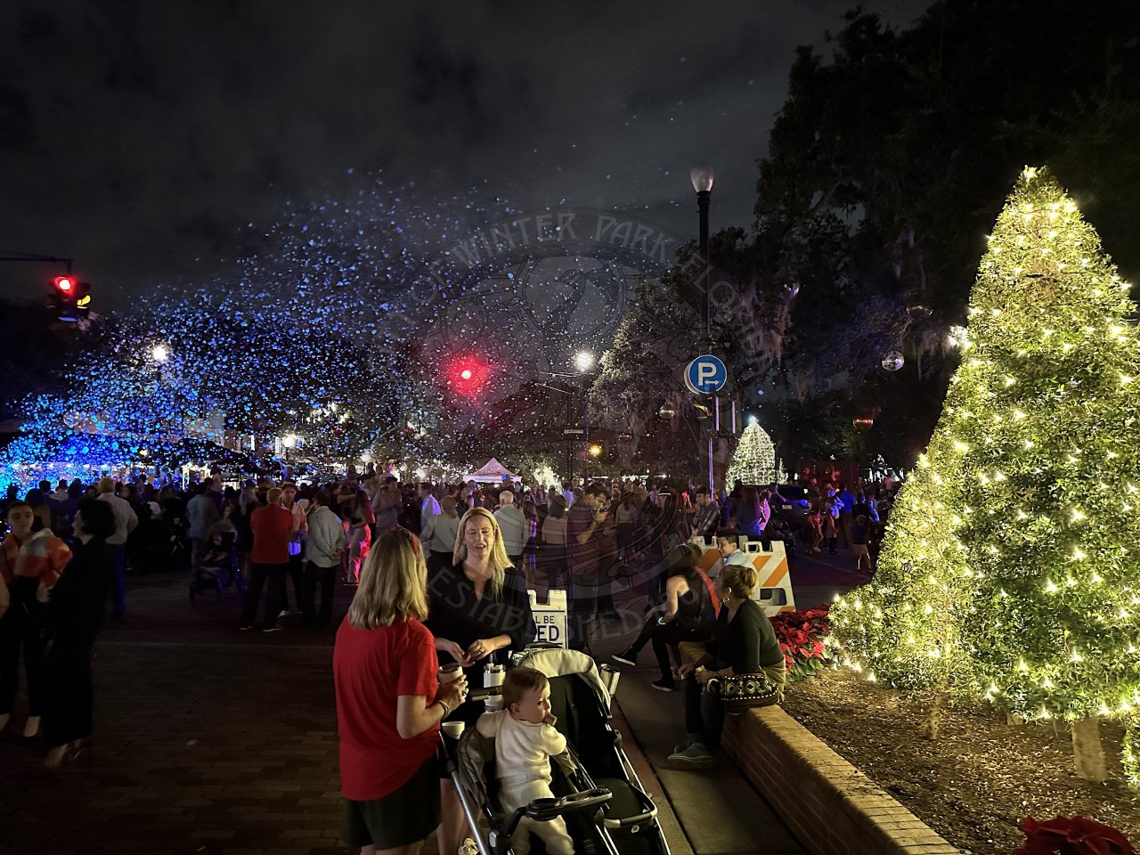 it is a crowded Park Avenue on a friday night with a christmas tree on the right, bubbles on the left, and in the back right is the famous Park Avenue Christmas tree.