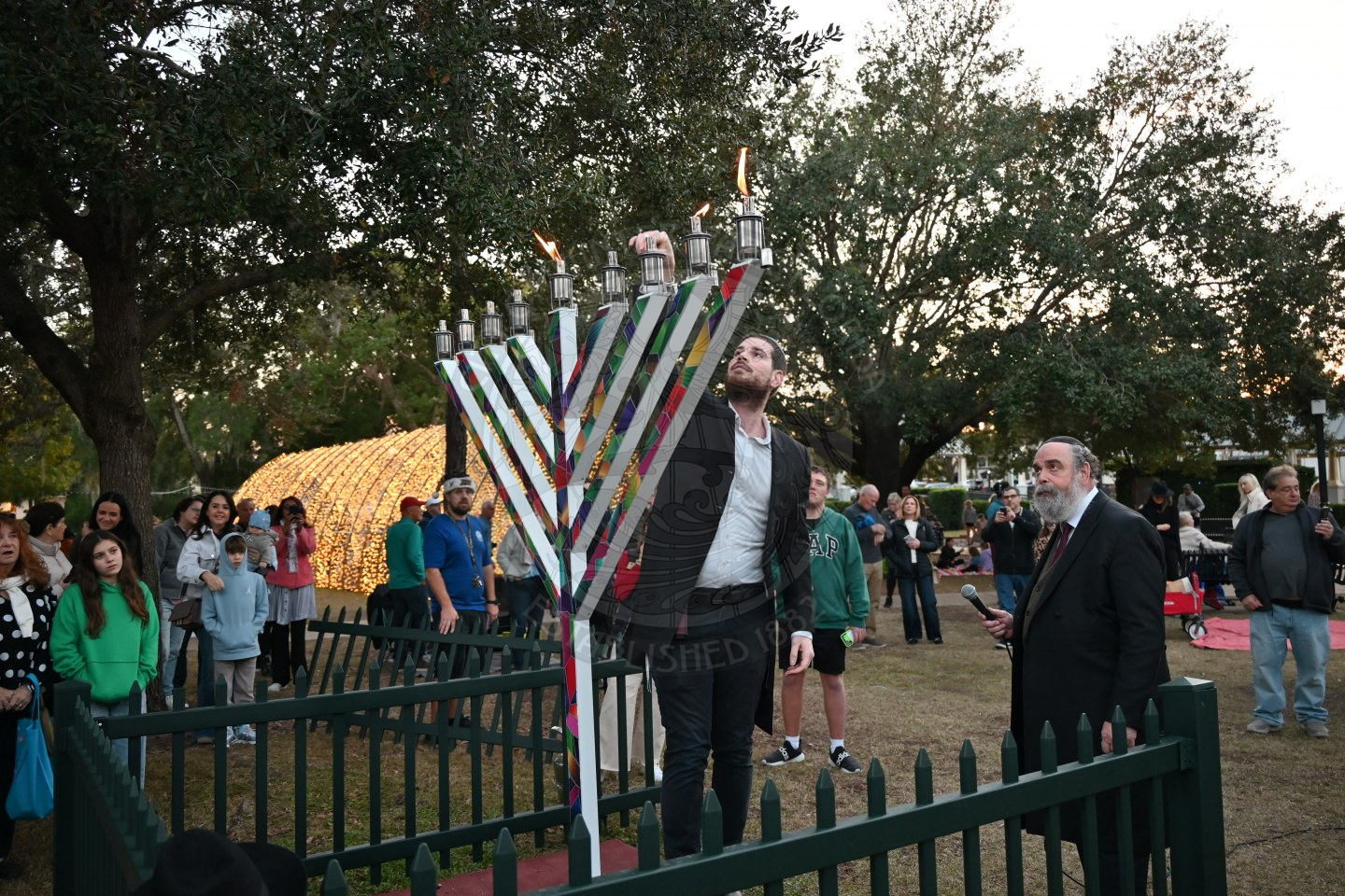 a rabbi lighting a menorah.