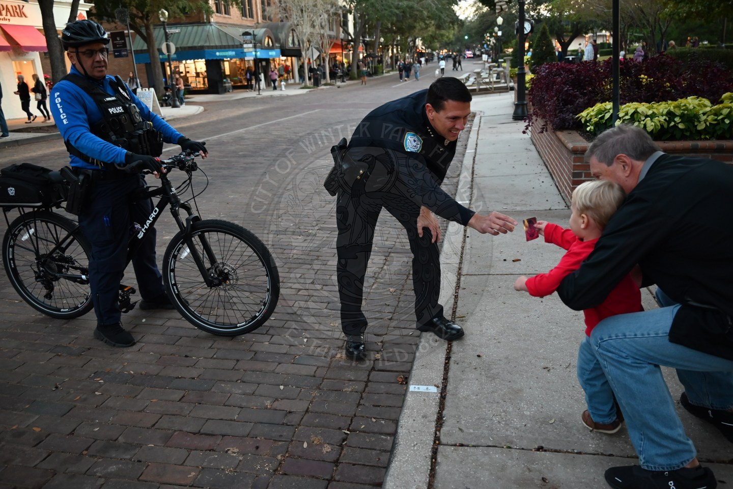 Police Chief grabbing something from a todler