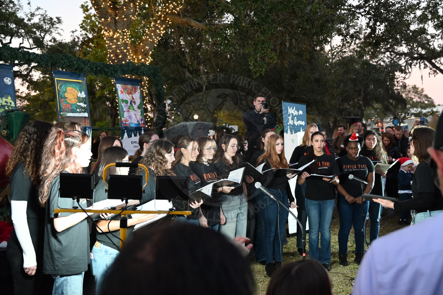 a group of teenagers performing christmas carols in front of everyone.