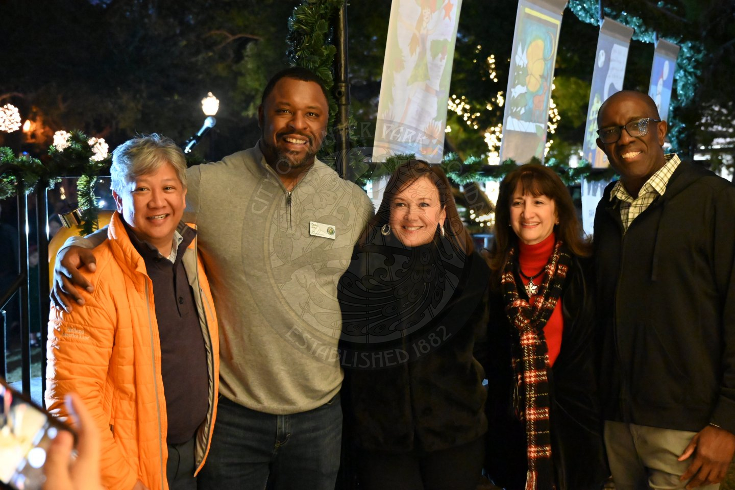 a group shot of elected officials smiling while standing behind a stage.
