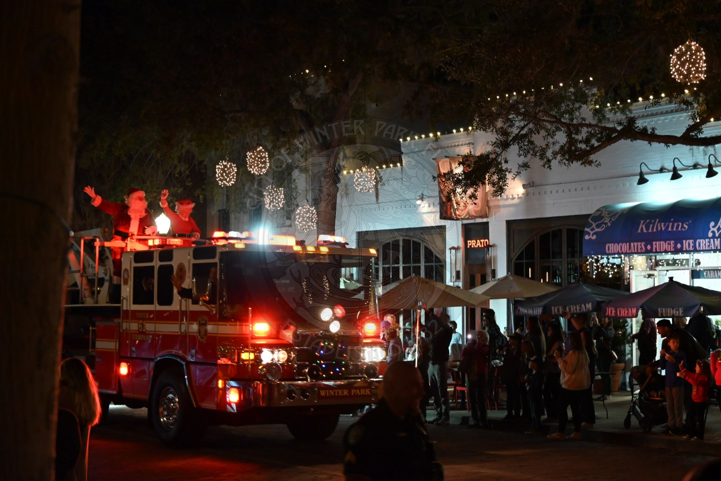 Mr. &amp; Mrs. Claus standing in the fire truck riding down park avenue