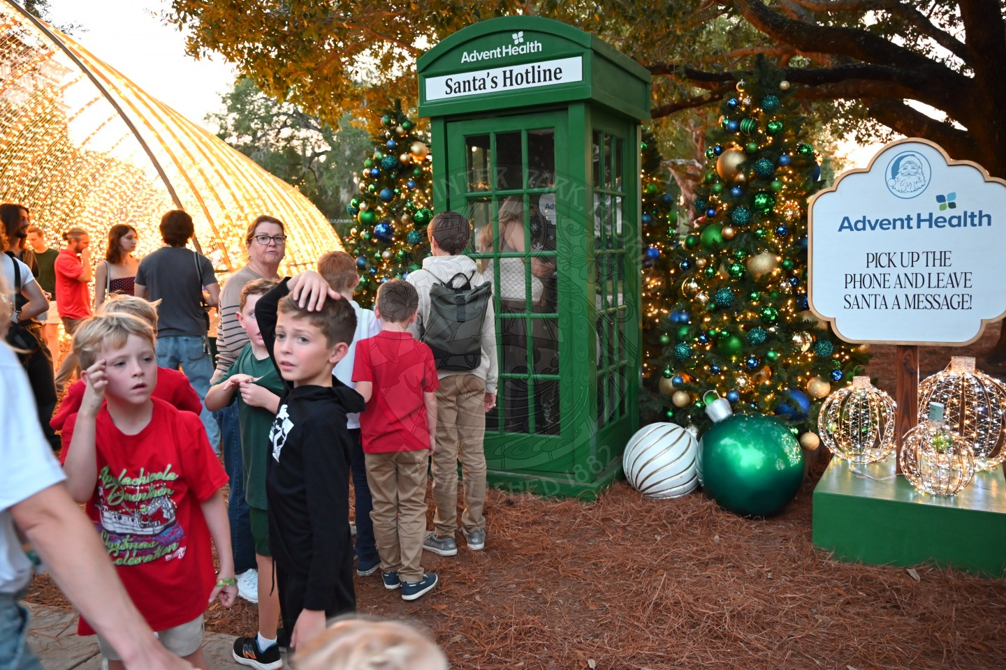 Santa's hotline phone booth with kids lined up outside of it to leave a message