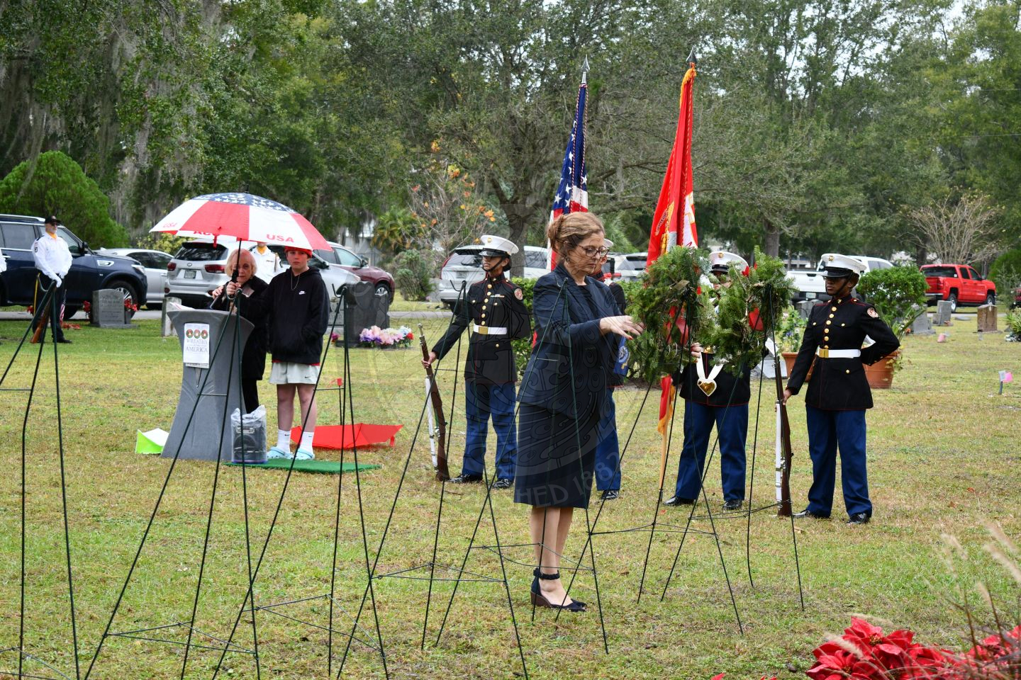 A woman placing a wreath on an easel.