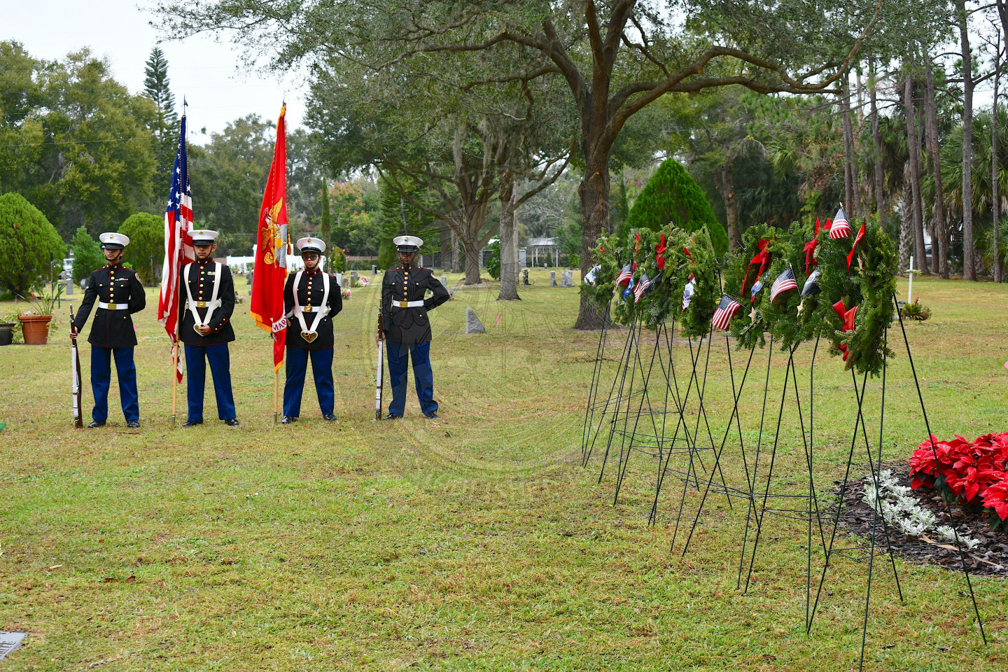 The color gaurd standing in line with the wreaths of each military branch on the right side.         