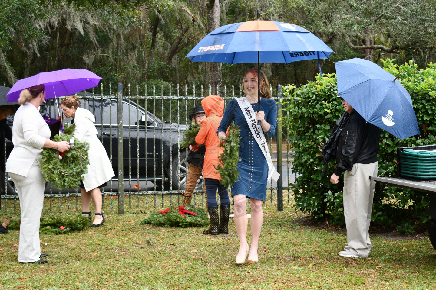 Miss Florida teen holding a wreath to place on a grave.