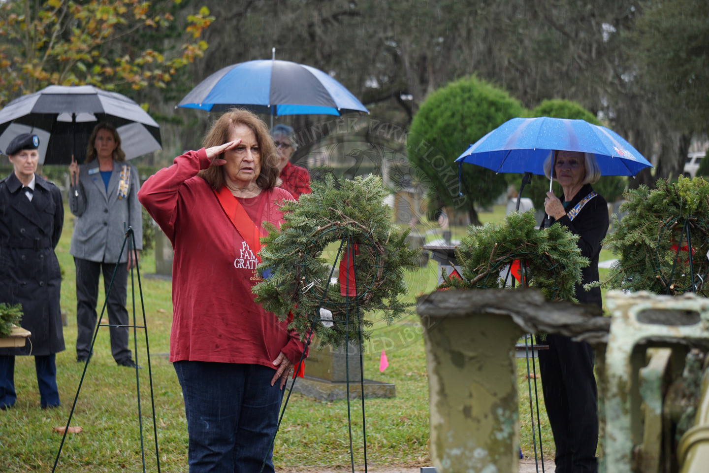 A woman placing the wreath on an easle.