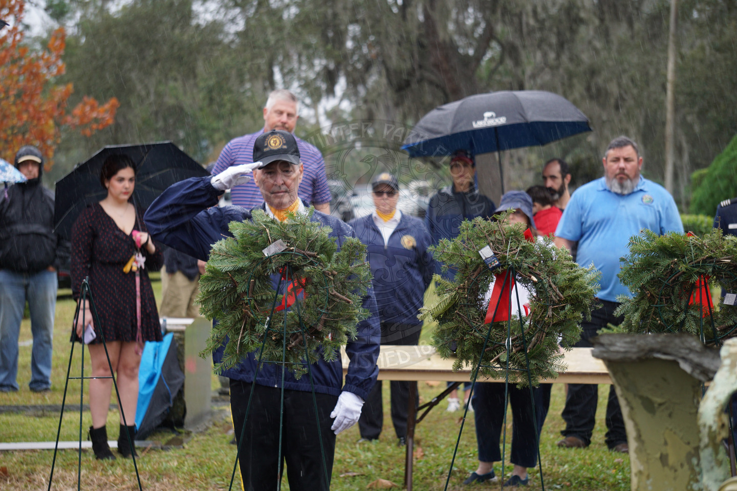 A man in uniform placing a wreath on the easel.