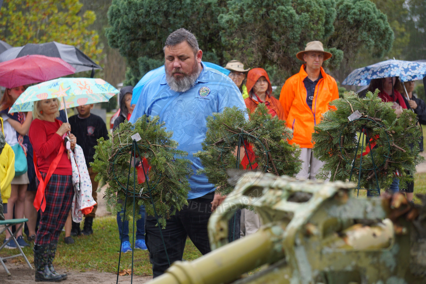 A man looking at the wreath he just places on an easle