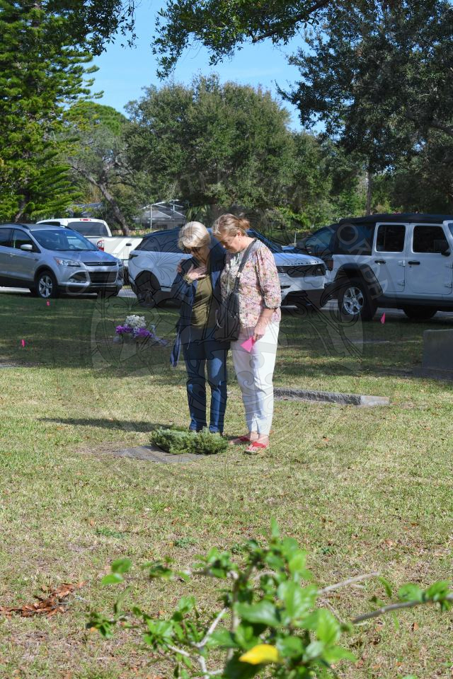 2 women laying down a wreath on a veteran grave at pineywood cemetary