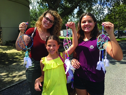 Three young ladies holding up their homemade dreamcatchers