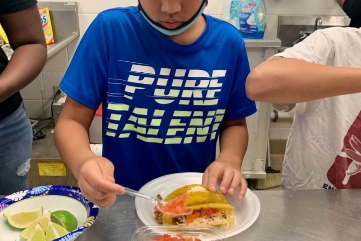 young boy making tacos