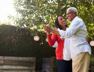 African American older adult couple dancing in outdoor setting