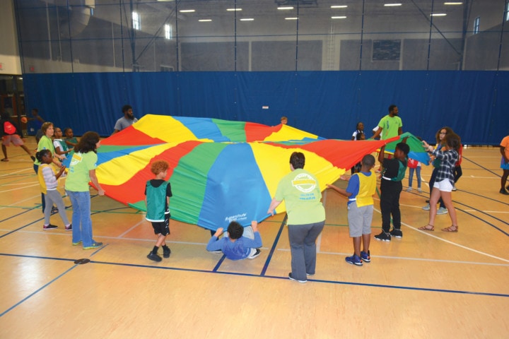 kids and teachers playing with playground parachute