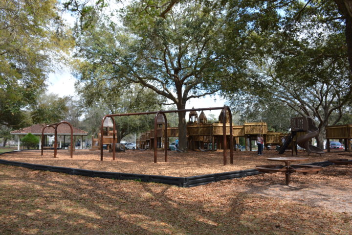 playgrund with a swingset and a wooden castle