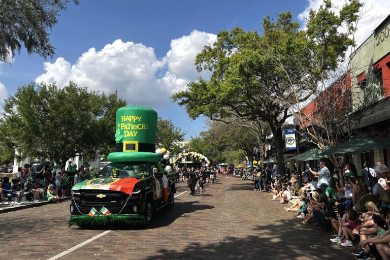 Truck driving in the parade with an inflatable with the words "Happy St. Patrick's Day"