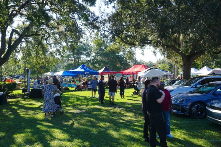 people looking at electric vehicles and getting information at sustainable booths