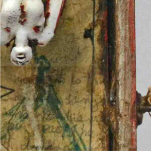 the head of a doll floating by thread above old paper with unreadable text.