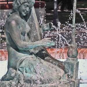 sculpture of a woman playing a harp in a fountain