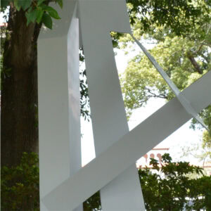 The sculpture resembles the letter "A" with abstract shapes with intersecting forms, painted in white.