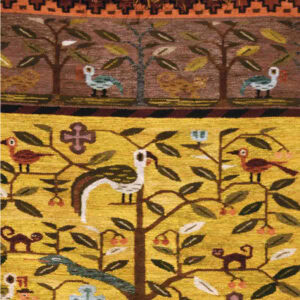 An embroidered rug with floral pieces and a tree