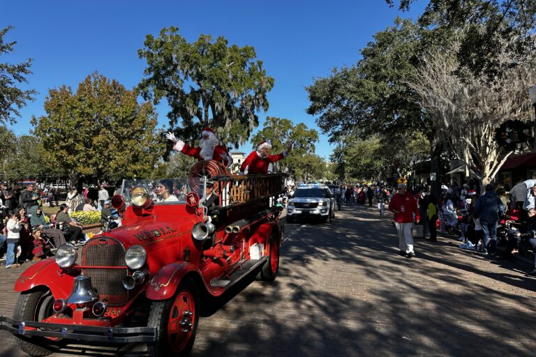 Santa and Mrs. Claus riding in a firetruck down park avenue.