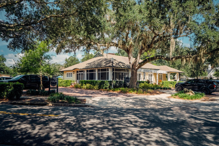 Charming historic building in Winter Park, Florida, surrounded by lush greenery and mature trees, showcasing the city's vibrant community and scenic beauty.