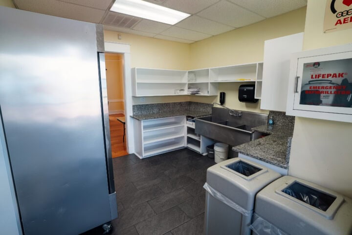 Functional kitchen in Winter Park city building with stainless steel refrigerator and granite countertops.