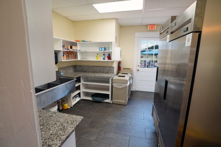 Clean community kitchen with stainless steel appliances, granite countertops, and access to outdoor areas with recycling bins supporting events and gatherings.