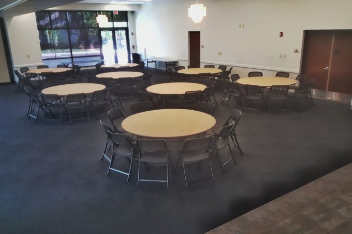 Oak Room event set-up example with round table and black chairs