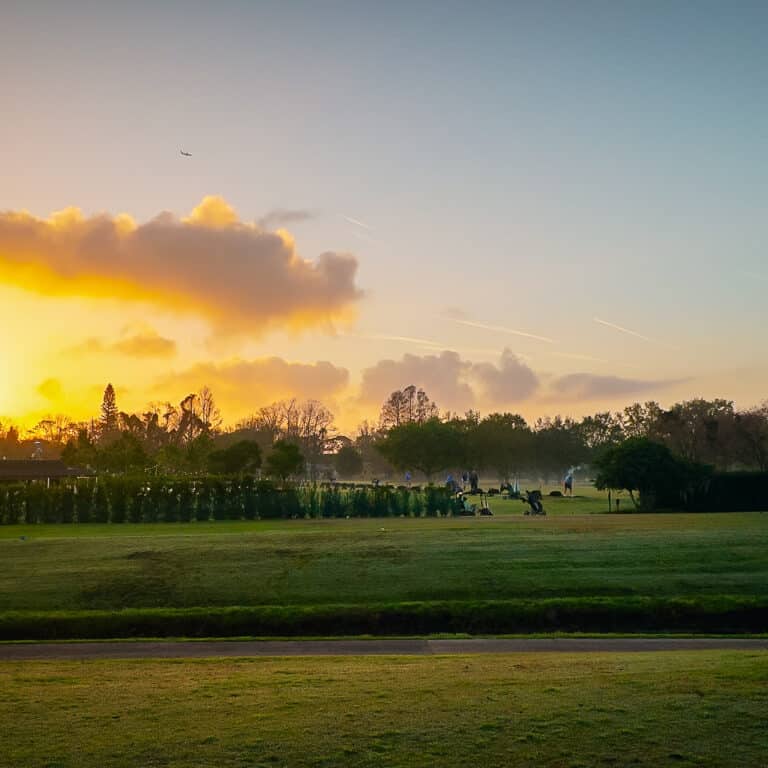 People golfing at sunrise on the Winter Park Pines golf course.